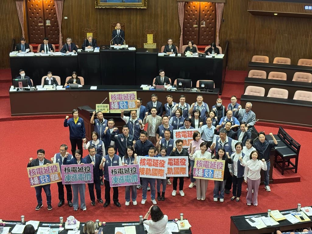 三讀通過後國民黨團合照留念，手板上寫著「延役」，民進黨譏諷「修了重啟法案都不知道」。攝影：李蘇竣