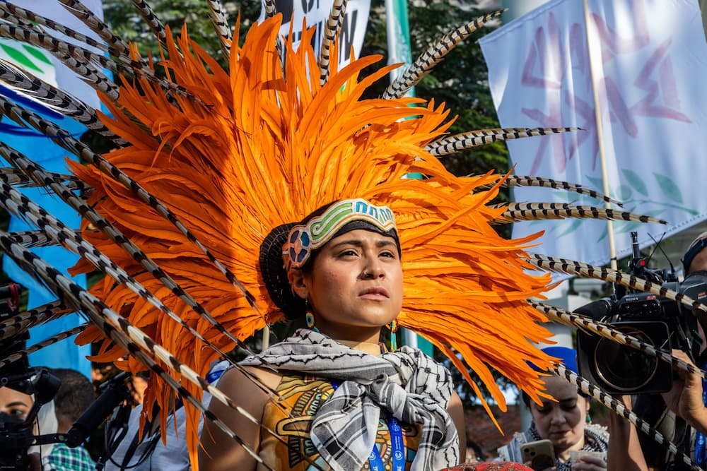 An Indigenous activist during demonstrations at the COP28 opening in Dubai, 2023. Civil society organisations called for an end to oil extraction, the protection of ecosystems and a ceasefire in Palestine (Image: Mídia NINJA / Flickr, CC BY NC)