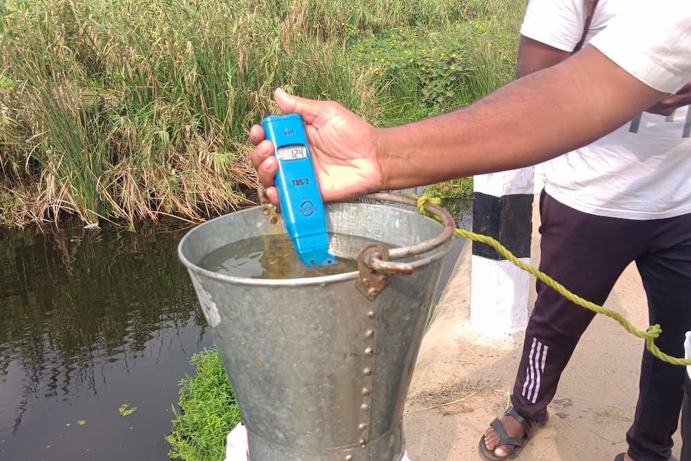 An activist tests water from the Palar River for total dissolved solids, a general measure of water quality. Readings indicate high levels of pollution, especially from salts (Image: Varsha Torgalkar)