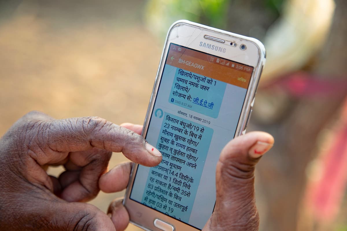 An elderly person in India reads a text message sent to them as part of an early warning system for floods (Image: Jake Lyell / Alamy)