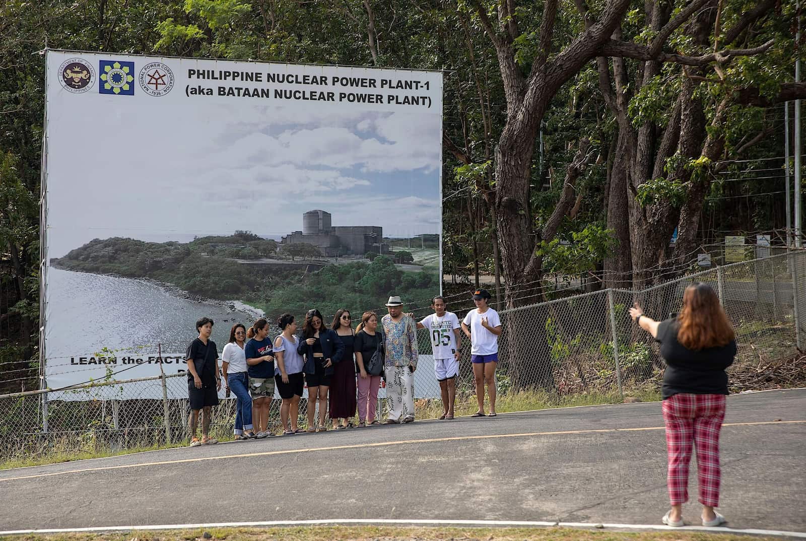 Tourists pose for a photo in front of a billboard advertising the Bataan Nuclear Power Plant. With the Philippines’ nuclear plans being revived after four decades, so is interest among a new generation – including potential nuclear engineering students (Image: Anton L. Delgado / Associated Press / Alamy)