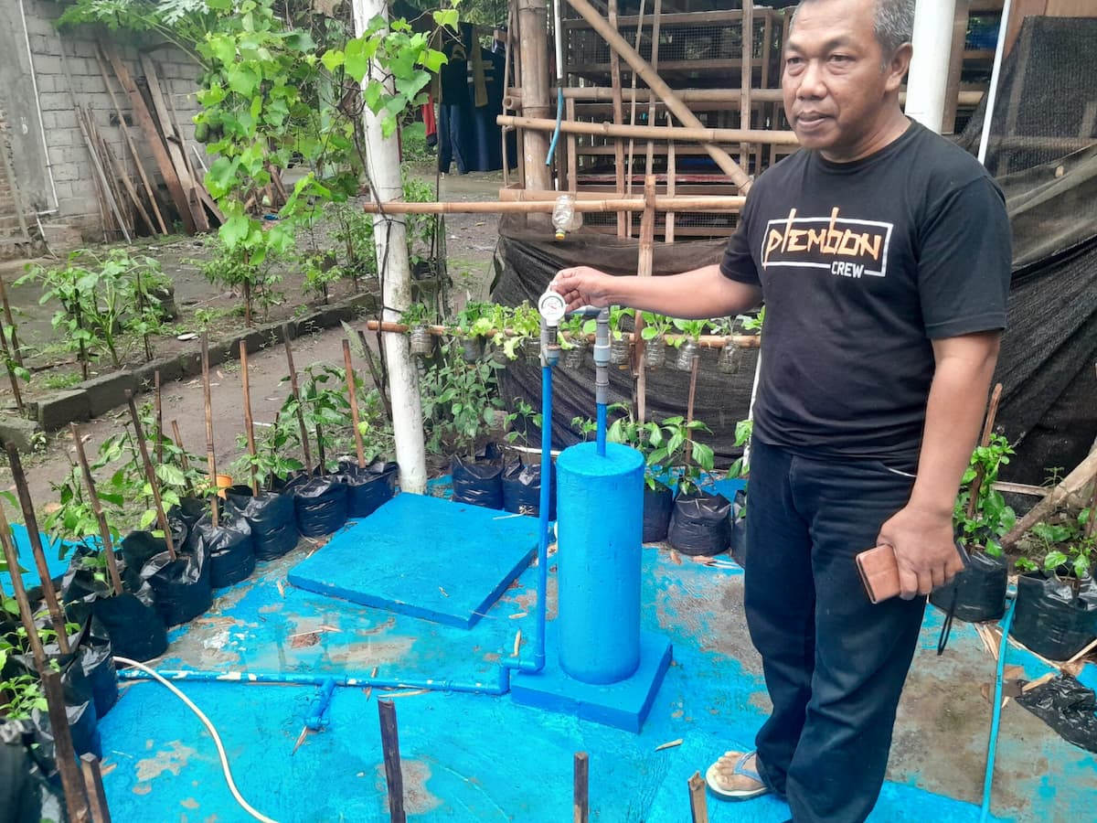 Suyono displays his biogas reactor. Image by Toto Sudiarjo/Mongabay Indonesia.