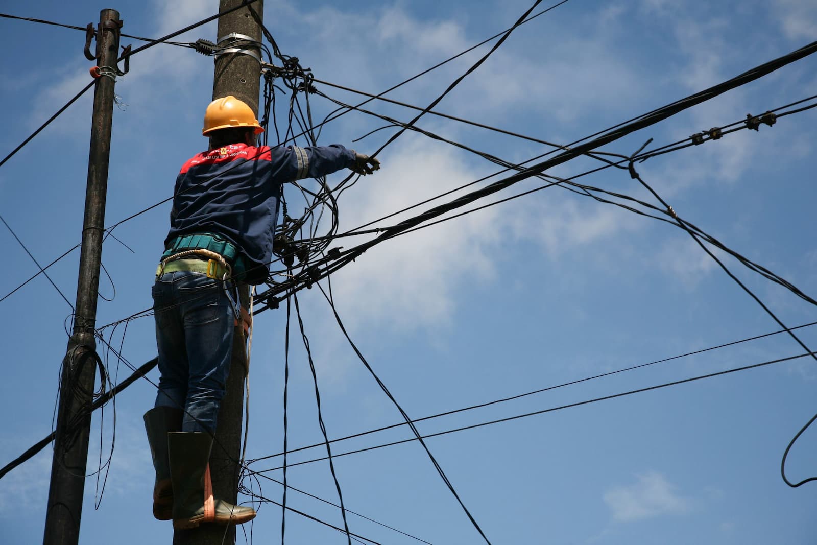 Workers repair the household electricity network in Bogor, Indonesia (Image: Kuncoro Widyo Rumpoko / Pacific Press / Alamy)
